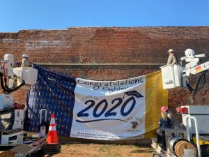 Cimarron hanging congratulatory banner for 2020 Kingisher seniors